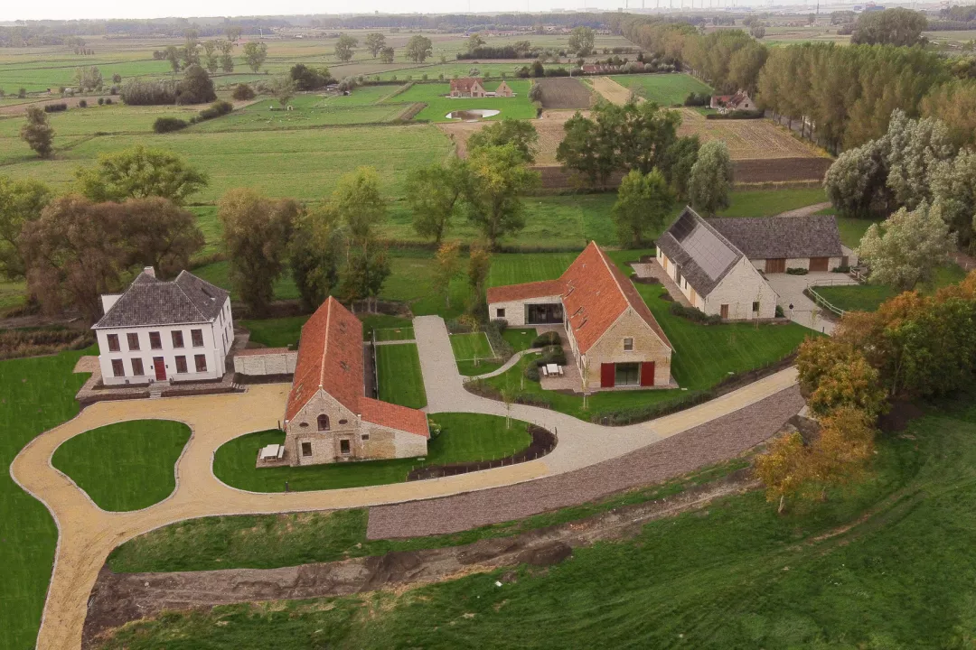 Drone view of De Snippe in Damme, showing the four separate buildings surrounded by greenery.